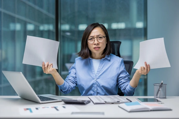 Stressed SME owner overwhelmed by compliance paperwork