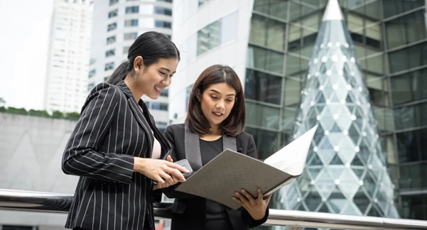 Two businesswomen reviewing compliance documents