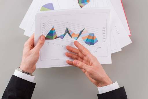 A person holding a document with financial charts, representing the importance of annual financial statements