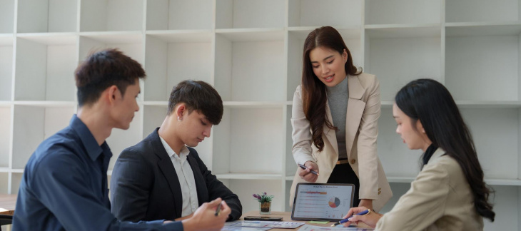 A business team reviewing documents and data discussing the steps to amend their company constitution.