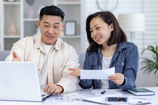 A business owner and his partner reviewing tax documents on a laptop, representing a smooth post-submission process with IRAS.