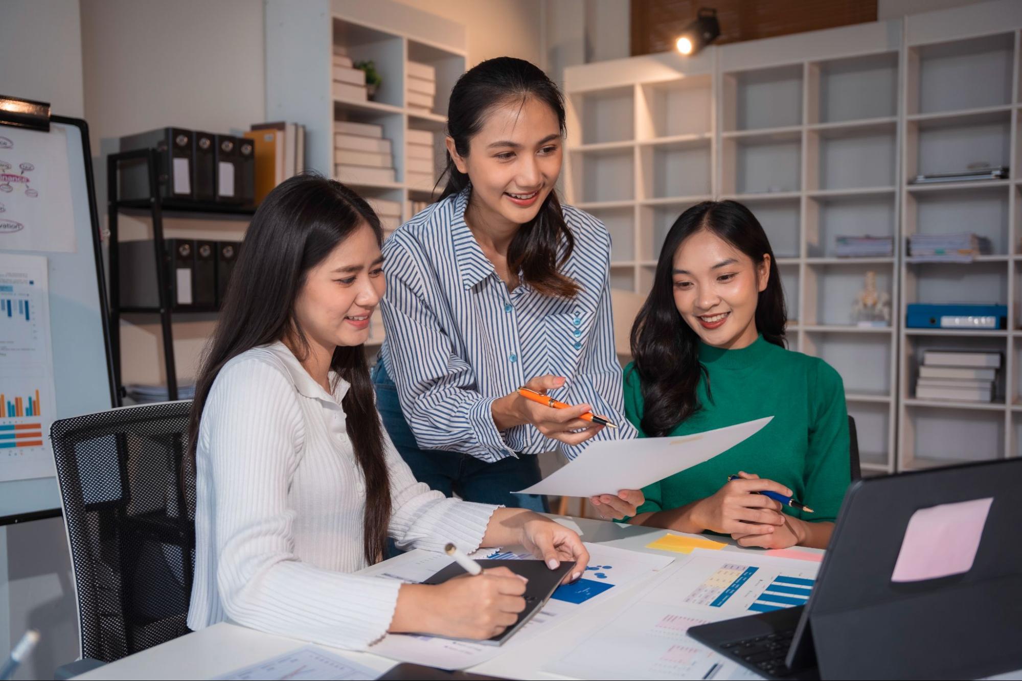 A corporate team analyzing digital financial statements and cash flow charts on a laptop during a monthly strategy meeting