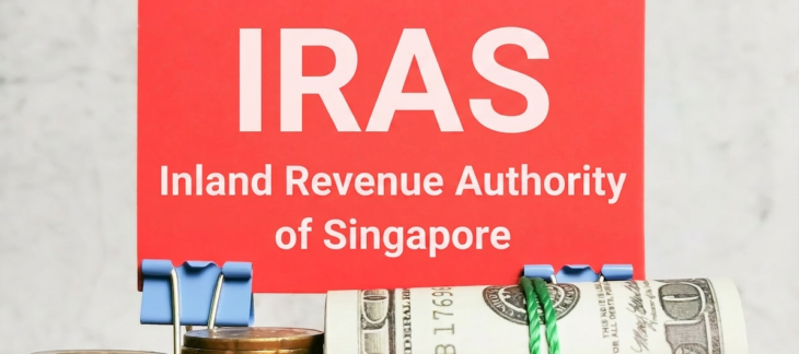 IRAS Inland Revenue Authority of Singapore sign displayed with stacked coins and bundled cash