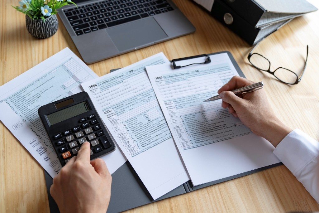 Completing IRAS Corporate Tax Forms Accurately Accountant completing corporate tax forms to ensure accurate IRAS filing compliance