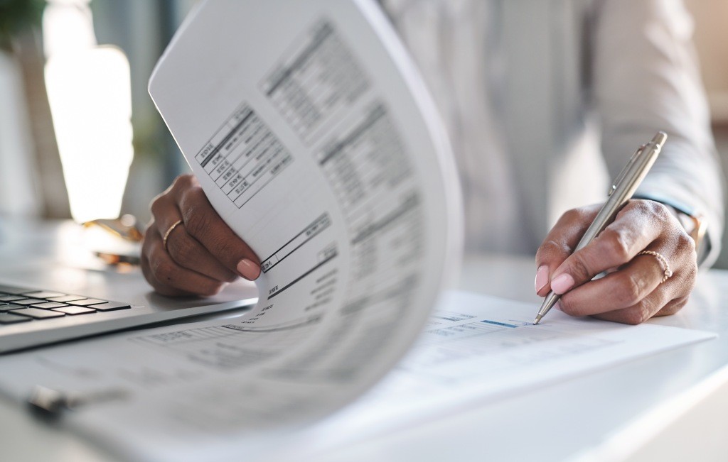 Reviewing Tax Returns to Avoid IRAS Late Filing Penalties Business owner reviewing tax return documents to avoid late filing penalties in Singapore