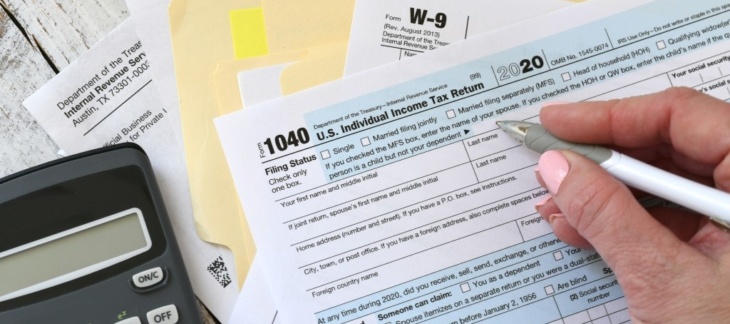 Tax filing forms and calculator on a desk representing IRAS corporate tax filing in Singapore